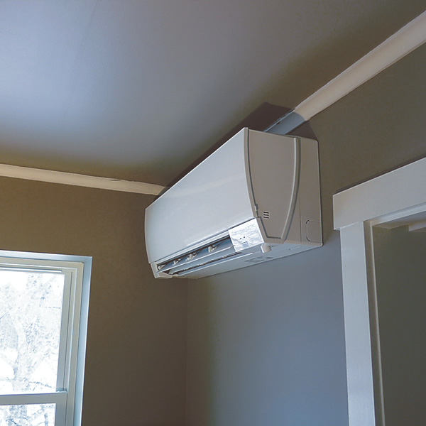 Ceiling HVAC ductless unit alongside residential wall